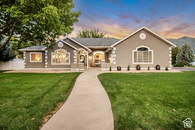 Single story home with a mountain view and a lawn