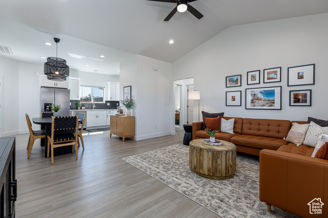 MODEL HOME IN PCTURE Living room featuring light wood-type flooring, ceiling fan, and high vaulted ceiling