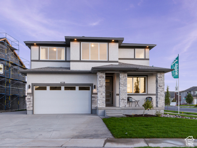 View of front of house with a lawn and a garage