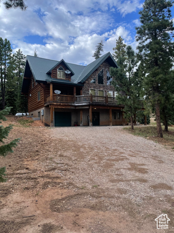 Log cabin with a garage and a wooden deck