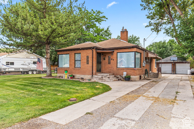 Bungalow featuring an outdoor structure, a garage, and a front yard