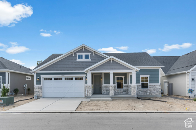 Craftsman inspired home with a garage, a porch, and central AC