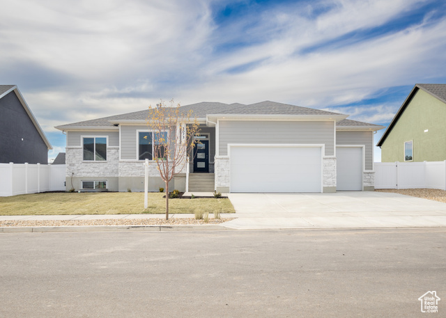 View of front of home with a garage and a front yard