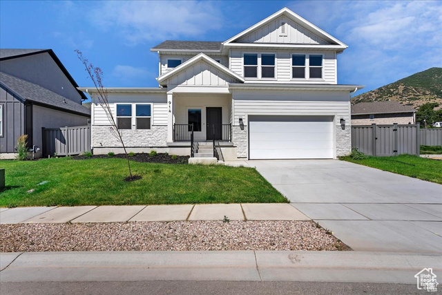 View of front of home with a front yard and a garage