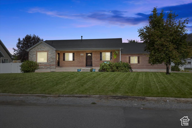 Single story home featuring a lawn