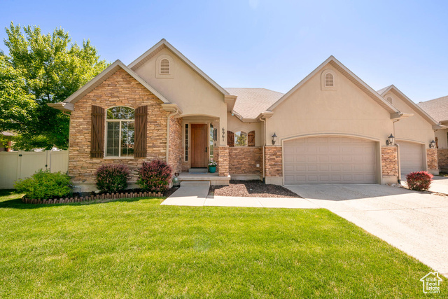 View of front of house with a garage and a front lawn