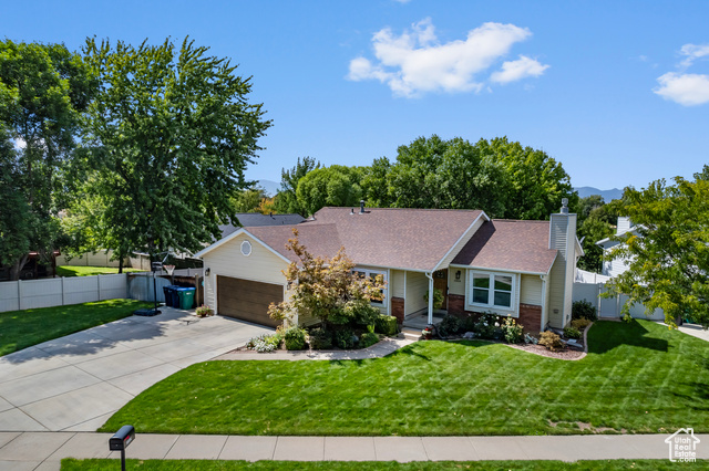 Ranch-style home featuring a garage and a front yard