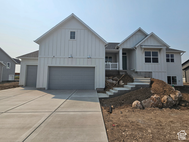 View of front of house featuring a garage and covered porch