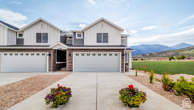 View of front of home with a garage and a mountain view