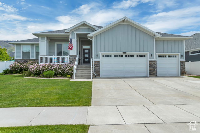 Craftsman inspired home featuring a front yard and a garage