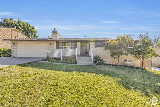 Single story home with a garage and a front yard