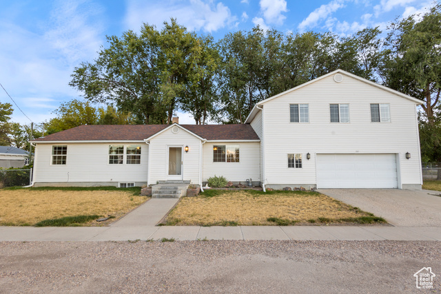 View of property with a front yard and a garage