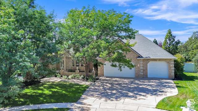 View of front of home with a garage and a front lawn