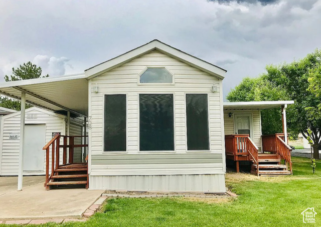 Back of property featuring a lawn and a shed