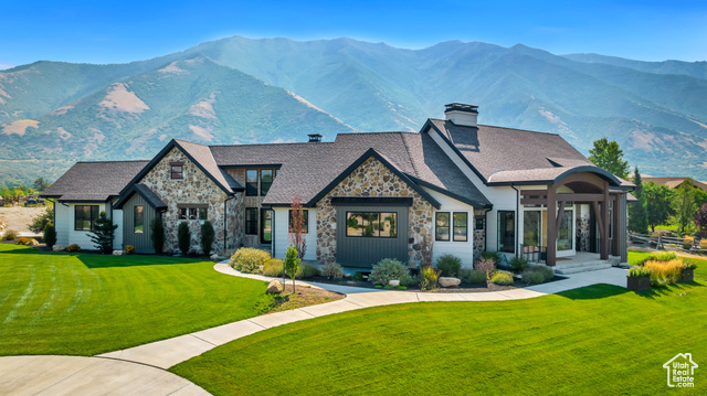 View of front of house with a front lawn and a mountain view