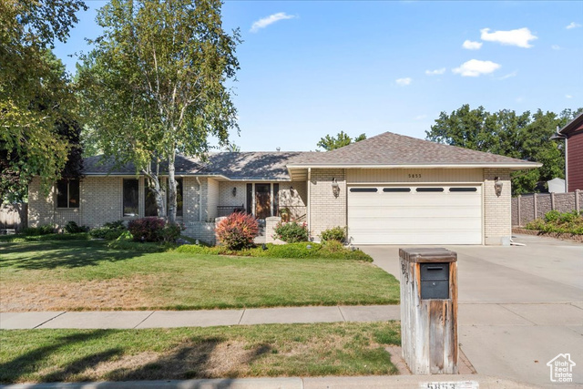 Single story home featuring a front lawn and a garage