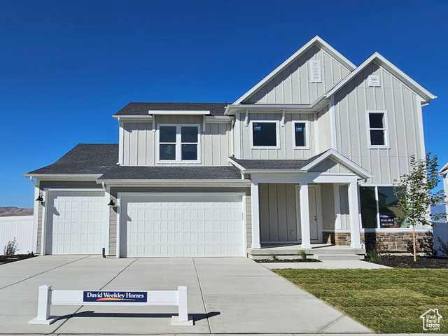 View of front of home featuring a front lawn and a garage