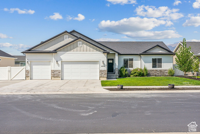 View of front of property with a garage and a front lawn