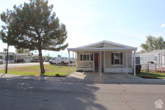 View of front of property with a front lawn and covered porch