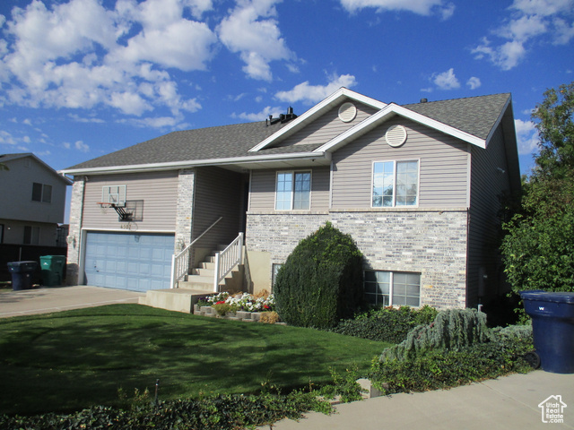 View of front of home featuring a garage and a front lawn