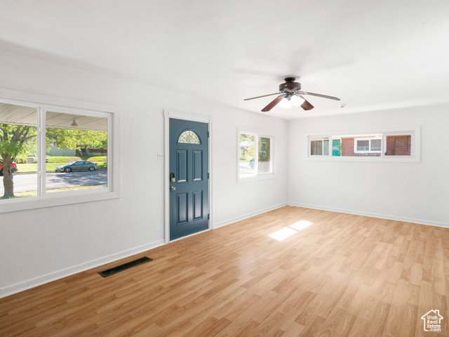 Foyer with light wood-type flooring, a healthy amount of sunlight, and ceiling fan