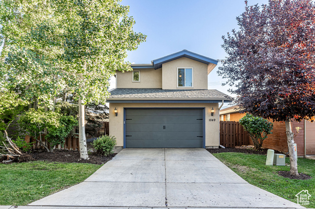 View of property with a garage and a front yardCurrent Garage Door.