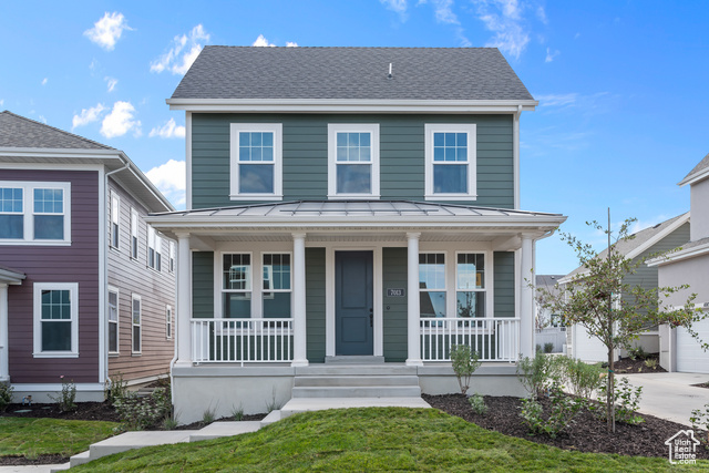 View of front facade with a garage, a porch, and a front yard