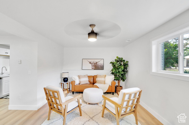 Living room with light hardwood / wood-style flooring, ceiling fan, and sink