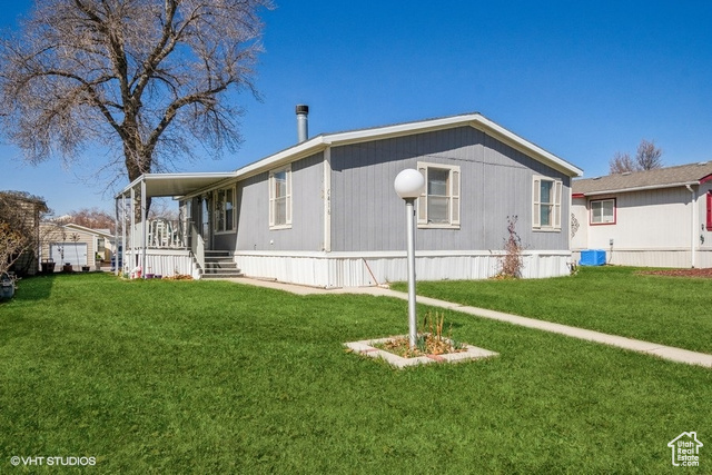 View of side of home with a yard