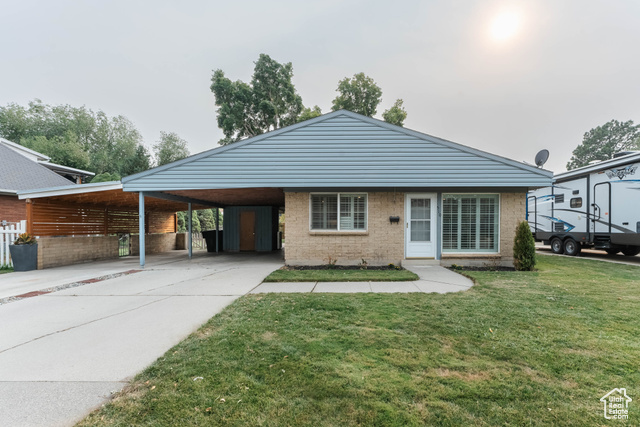 View of front of house featuring a front yard and a carport