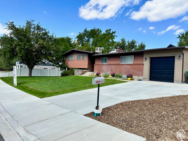 View of front of home featuring a garage and a front lawn