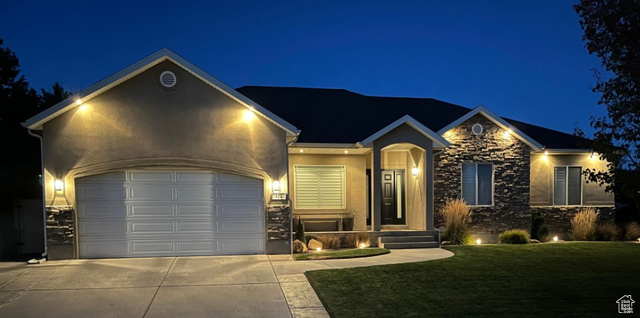 View of front of home featuring a garage and a lawn