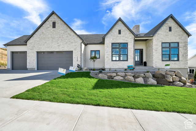 View of front of house featuring a front yard and a garage