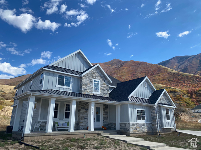 View of front of property with a porch and a mountain view