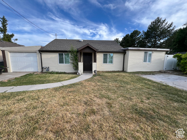 Single story home featuring a front lawn and a garage