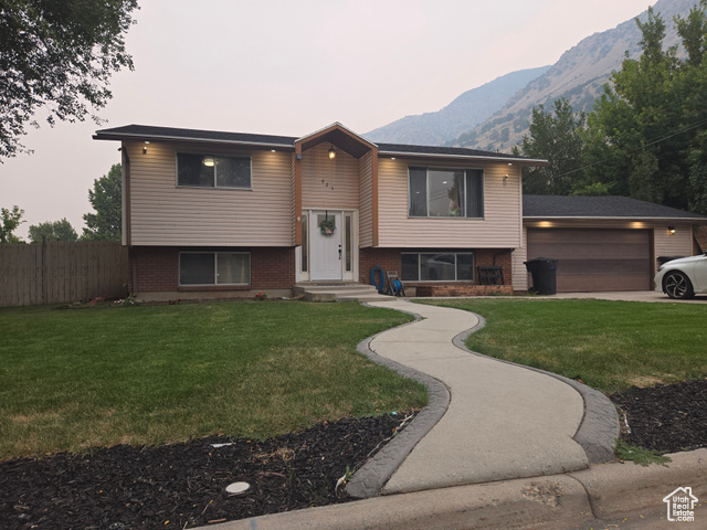 Split foyer home with a yard, a garage, and a mountain view