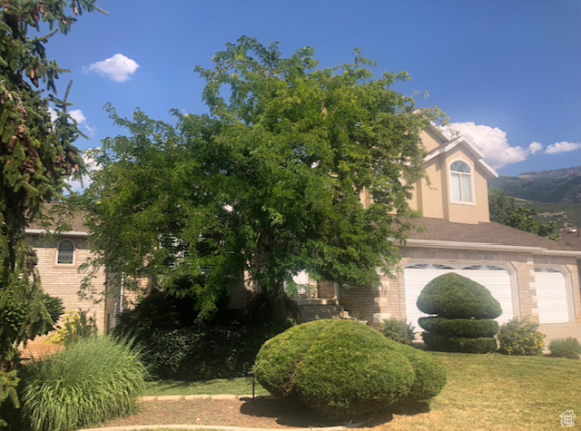 View of front of house featuring a garage and a front lawn