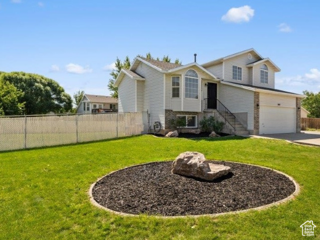 View of front of property with a front lawn and a garage