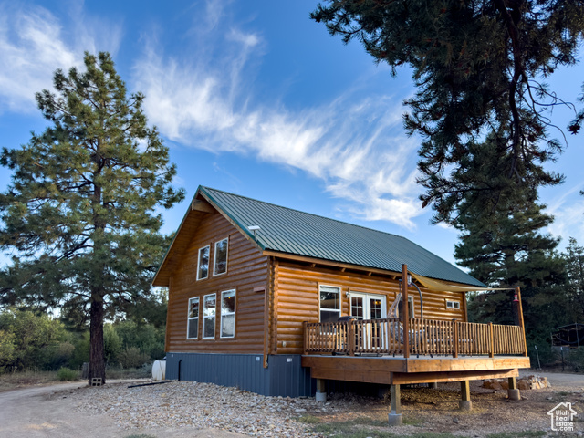 View of side of home featuring a wooden deck