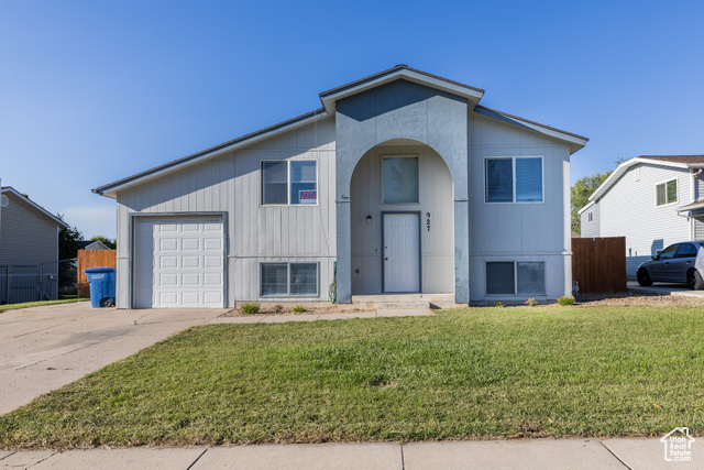 View of front of home featuring a front yard and a garage