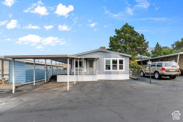 Manufactured / mobile home featuring covered porch and a carport