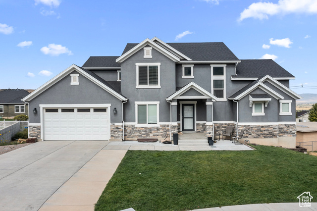 Craftsman-style house with a garage and a front lawn