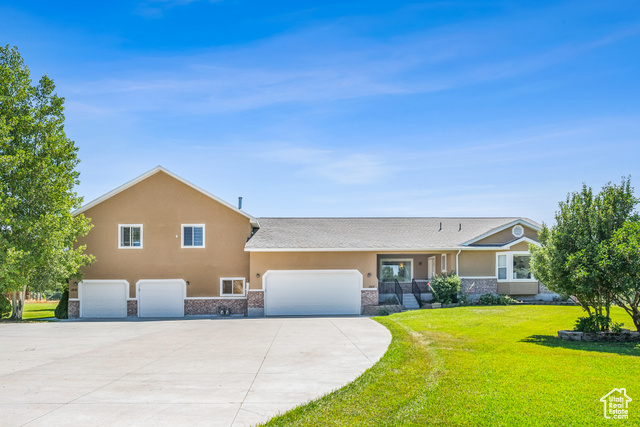 View of front of property with a garage and a front lawn