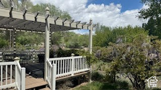 Exterior space with a wooden deck and a pergola