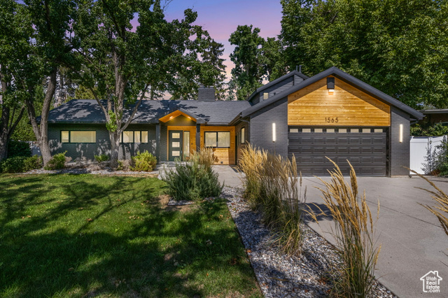 View of front of property featuring a yard and a garage