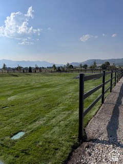 View of gate featuring a mountain view, a rural view, and a yard