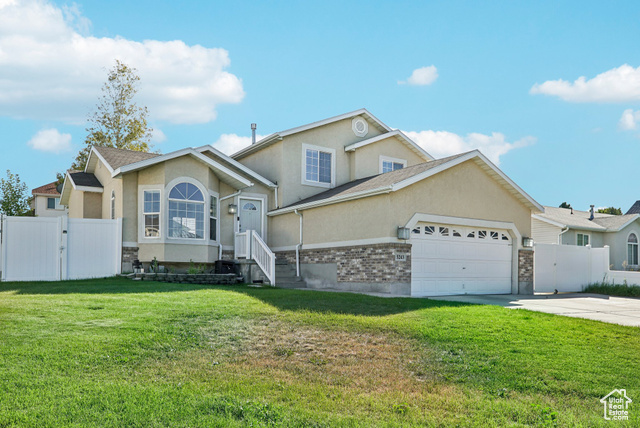 View of front of home featuring a garage and a front lawn