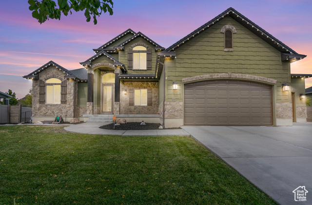 View of front of house featuring a garage and a lawn