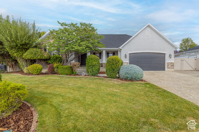 View of front facade featuring a front yard and a garage