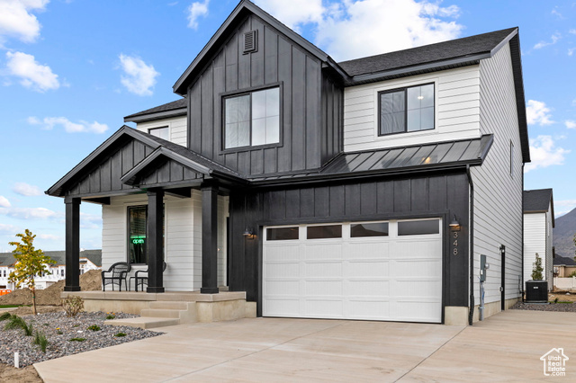 Modern farmhouse style home with central AC, a porch, and a garage